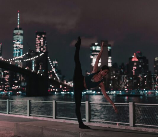 체육 18년차 경력 대표 직강 바레 지도자과정 woman in black sports bra and tights doing ballet position on sidewalk during nighttime