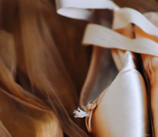 왜 어떤 바레 수업은 힘들기만 하고 몸은 안 바뀔까? a pair of ballet shoes laying on top of a bed