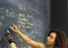 회원은 운동이 아니라 강사를 따라옵니다 | 필라테스,바레, 스텝박스자격증 Two adults in fitness gear analyze workout plans on a chalkboard in a gym setting.