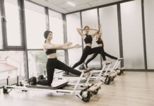 매봉역 필라테스 & 바레 추천, 체형교정이 먼저인 이유 Three women engaged in Pilates exercises on reformer machines in a bright, modern gym setting.